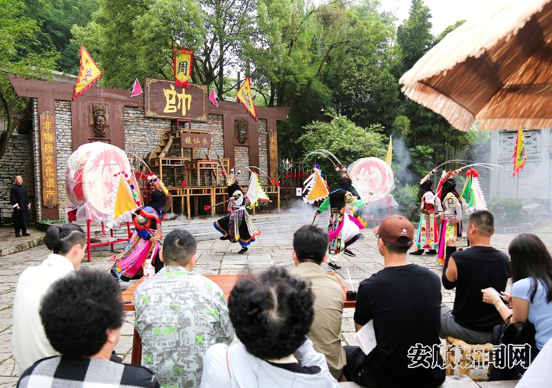 5月25日，游客在天龙古镇观看安顺地戏表演。当日，天龙古镇地戏队员在天龙学堂前为专程前来的青岛游客展示有着600多年历史的屯堡地戏，精彩的表演令游客赞叹不已。（安顺日报融媒体中心记者 卢维）