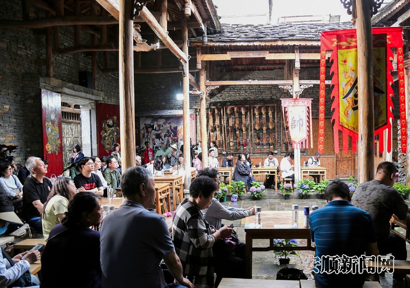 5月25日，游客在天龙古镇观看安顺地戏表演。当日，天龙古镇地戏队员在天龙学堂前为专程前来的青岛游客展示有着600多年历史的屯堡地戏，精彩的表演令游客赞叹不已。（安顺日报融媒体中心记者 卢维）