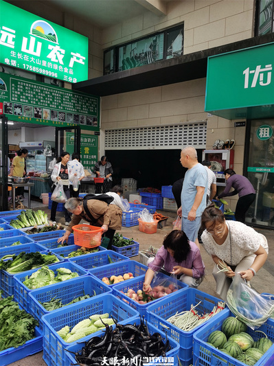 顾客正在挑选新鲜的蔬果。李坤 摄.jpg