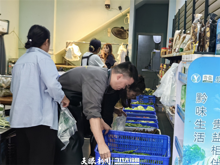 工作人员正在摆放刚到店的农特产品，已有顾客前来购买。牟绍莉 摄.jpg